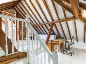 an attic staircase with white railings and wooden beams at The Courtyard in Pulborough