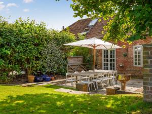 a table and chairs with an umbrella in a yard at The Courtyard in Pulborough