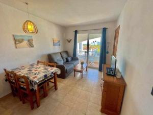 Turqueta - Apartamento con piscina junto la playa في كالا إن بلانيس: غرفة معيشة بها طاولة وأريكة
