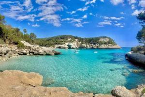 Turqueta - Apartamento con piscina junto la playa في كالا إن بلانيس: اطلالة على خليج به قوارب في الماء