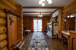 una sala de estar con chimenea y paredes de madera. en Koruna en Tatariv