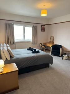 a bedroom with a large bed with a desk and a desk at Eton Court Apartments in Newquay
