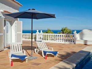 - deux chaises et un parasol à côté de la piscine dans l'établissement Villa Batavia by Interhome, à Balcon del Mar