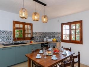 a kitchen with blue cabinets and a wooden table at Holiday Home Hermine by Interhome in Sant Martí d’Empúries