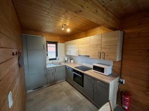 a small kitchen with wooden cabinets and a microwave at Holiday Home Funke by Interhome in Hasselfelde