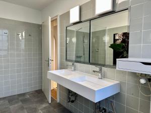 a bathroom with two sinks and a mirror at Exklusiver Rheinblick fussläufig zur Messe! in Düsseldorf