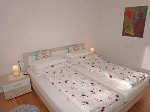 um quarto com uma grande cama branca com flores em Apartment Muehlbach by Interhome em Fliess