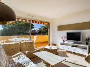 a living room with a couch and a tv at Apartment Cadet Rousse by Interhome in Le Lavandou