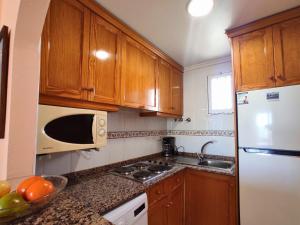 卡拉代法恩斯特拉的住宿－Apartment Agua Viva by Interhome，厨房配有木制橱柜和白色冰箱。