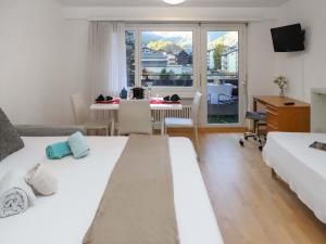 1 dormitorio con 2 camas y mesa con escritorio en Apartment Residence A-3 by Interhome en Zermatt