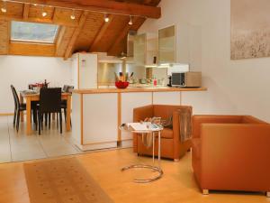 Apartment Brigitte by Interhome في زيرمات: مطبخ وغرفة معيشة مع طاولة وكراسي
