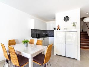uma cozinha branca com uma mesa e cadeiras brancas em Apartment La Méridienne-3 by Interhome em Le Lavandou
