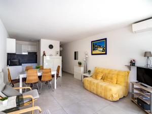 uma sala de estar com um sofá amarelo e uma mesa em Apartment La Méridienne-3 by Interhome em Le Lavandou