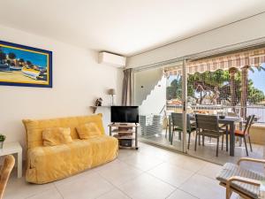uma sala de estar com um sofá amarelo e uma sala de jantar em Apartment La Méridienne-3 by Interhome em Le Lavandou