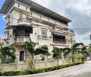 a white building with palm trees in front of it at Apartment Huz Peer 3 in Trou aux Biches