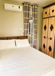 a bedroom with a white bed and a radiator at Apartment Huz Peer 3 in Trou aux Biches