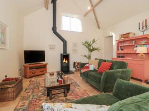 a living room with a couch and a fire place at The Hayloft in Honiton