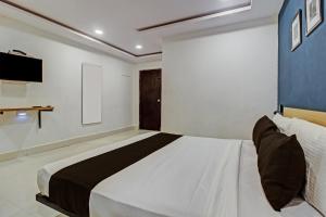 ein Schlafzimmer mit einem großen Bett und einem TV in der Unterkunft Super OYO SilverKey 79803 Qualia Miyapur in Kondapur