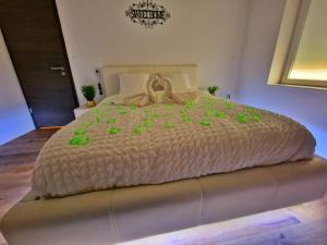 a bedroom with a large bed with green flowers on it at ZEN SPA-4 Pers-Jacuzzi-Parking-Clim-Colmar in Colmar