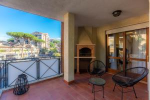 a balcony with two chairs and a fireplace at LU Apartment Eur in Rome