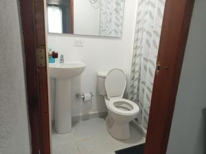 a bathroom with a white toilet and a sink at Cómodo apartamento in Jericó
