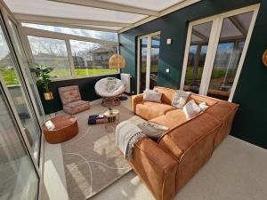 ein Wohnzimmer mit einem Sofa und einem Stuhl in der Unterkunft BNB Green refuge: Vakantiehuis met zeer grote tuin in Londerzeel