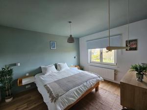 Un dormitorio con una cama grande y una ventana en BNB Green refuge: Vakantiehuis met zeer grote tuin, en Londerzeel