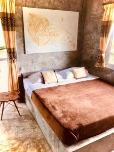 1 dormitorio con 1 cama y una pintura en la pared en New Moon, en Thong Sala