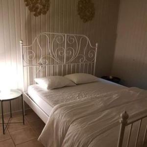 un lit dans une chambre avec un cadre de lit blanc dans l'établissement Chalet 't Vraagteken, à Durbuy