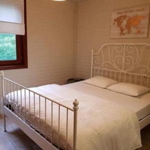 1 dormitorio con cama blanca y ventana en Chalet 't Vraagteken, en Durbuy