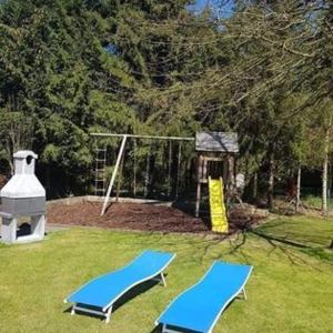 - deux chaises bleues dans une cour avec un tapis de volley-ball dans l'établissement Chalet 't Vraagteken, à Durbuy