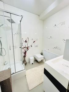 baño blanco con ducha y lavamanos en Pure Luxury Residence, en Timisoara