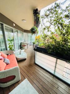 Pure Luxury Residence في تيميشوارا: غرفة معيشة مع نافذة كبيرة بها نباتات