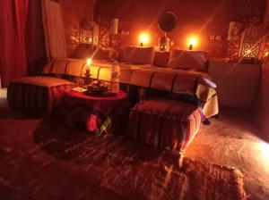 a room with two beds and two tables and candles at Desert Bivouac Mhamid in Mhamid