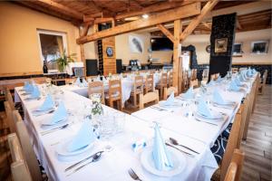 Długa jadalnia z białymi stołami i krzesłami w obiekcie Hotel Taurus w Ostravie