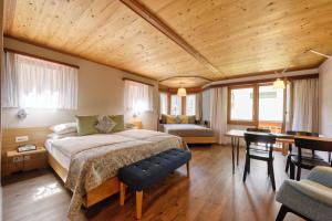 a bedroom with a bed and a desk in a room at Hotel Simi in Zermatt