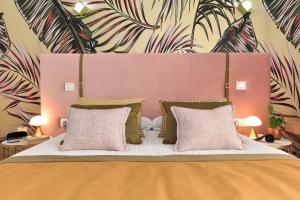 una camera da letto con un grande letto con cuscini rosa e verde di Apartamento Deluxe en Cruce de Arinaga GRANEL a Cruce de Arinaga