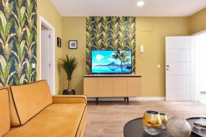 a living room with a couch and a flat screen tv at Apartamento Deluxe en Cruce de Arinaga GRANEL in Cruce de Arinaga