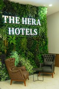 een groene muur met twee stoelen en het bordje heldenhotels bij The Hera Business Hotels & Spa in Istanbul