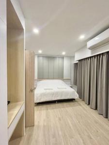 um quarto com uma cama grande num quarto em The Commune 101 em Roi Et