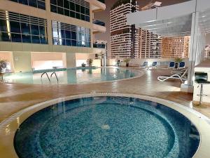 ein großer Pool in einem großen Gebäude in der Unterkunft Dubai Marina Oasis Studio near in JBR in Dubai