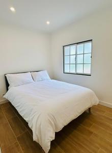 a white bed in a room with a window at Casa Martins Country Apt, No.6 in Freiria
