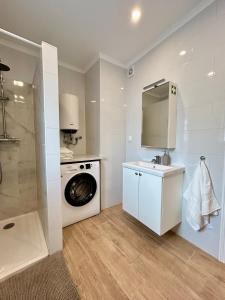 a white bathroom with a washing machine and a sink at Casa Martins Country Apt, No.6 in Freiria