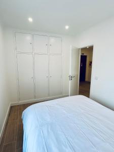 a bedroom with a large bed with white cabinets at Casa Martins Country Apt, No.6 in Freiria