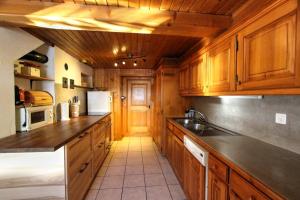 a kitchen with wooden cabinets and a counter top at MomenTine Appartement B&B in La Tine