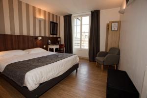 een hotelkamer met een bed en een stoel bij Hôtel Océan Dinan in Dinan