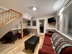 - un salon avec un canapé rouge et un escalier dans l'établissement Cozy 2 Bedroom Waterfront Cottage With Hot Tub!, à Ucluelet