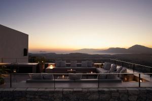 LístarosにあるAskianos Luxury Villas - An Oasis of Harmony & Eleganceのソファ付きのリビングルーム、夕日を提供しています。