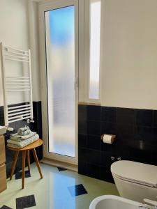 uma casa de banho com um WC, uma mesa e uma janela em The Design Pasta Apartment em Roma