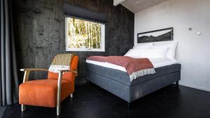 ein Schlafzimmer mit einem Bett, einem Stuhl und einem Fenster in der Unterkunft Engeset Trehytter in Vereide
